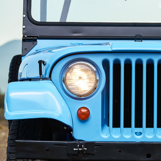 Front view of a Jeep Wrangler with round headlights and grille.