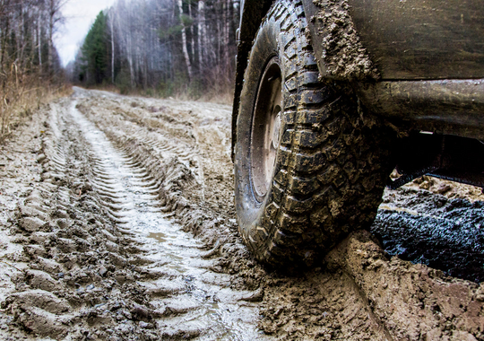 Jeep Wrangler YJ tire on a muddy road with tire tracks